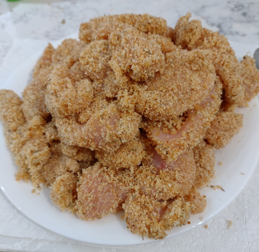 Uncooked crumbed chicken pieces.